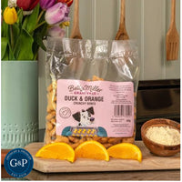 The treats are shaped like bones and feature a rich, golden-brown colour with flecks of orange. Perfect for rewarding dogs with a tasty and nutritious snack. Available at Growler & Prowler Manchester.